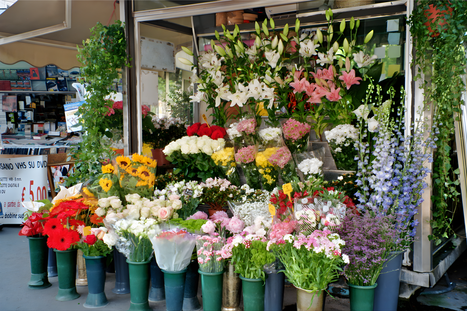 An outdoor flower stall displays an abundant variety of fresh floral arrangements and bouquets near Bond Street. The arrangement includes white lilies with large, unopened buds and pink lilies with op